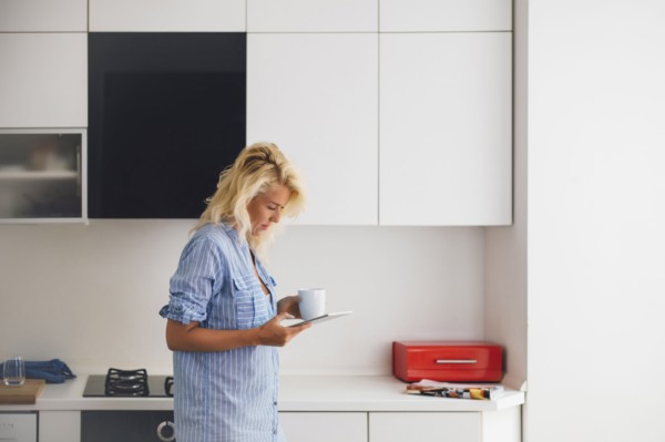 Woman using digital tablet in kitchen