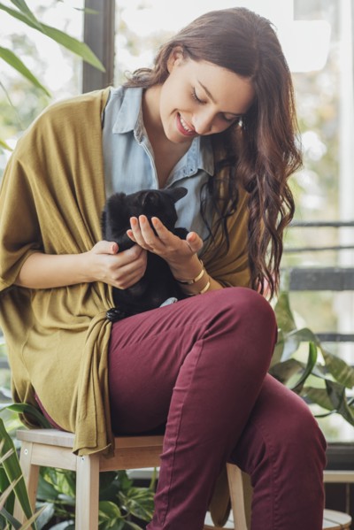 Caucasian woman holding kitten