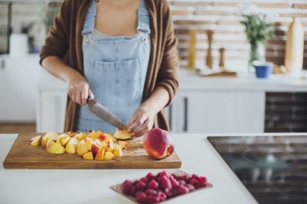Caucasian woman chopping fruit in kitchen
