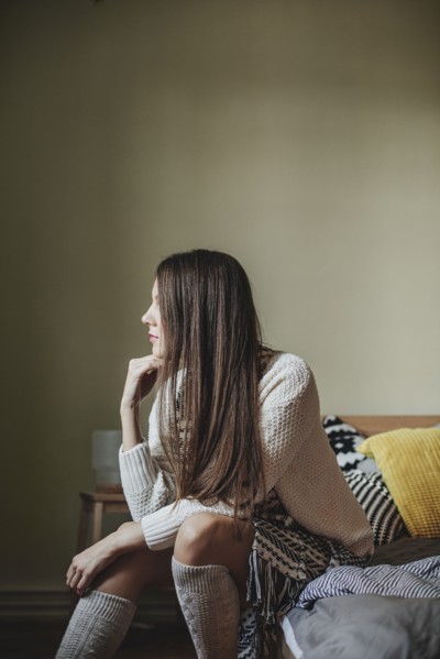 Caucasian woman sitting on bed