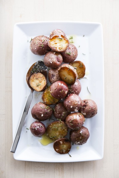 Spoon on plate of roasted potatoes