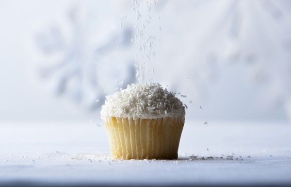 White sprinkles falling on vanilla cupcake