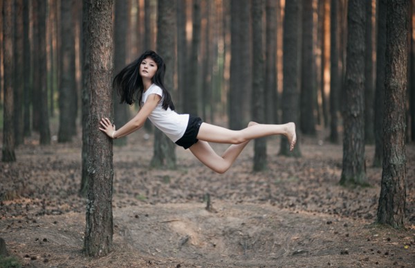 Caucasian woman floating in forest