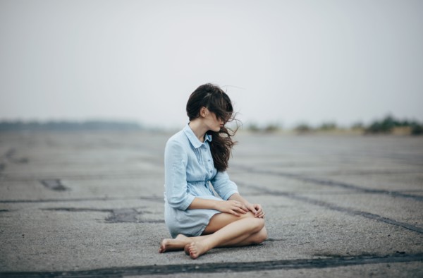 Caucasian woman sitting on concrete