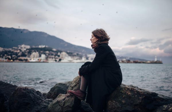 Caucasian woman admiring coastline from rock formation