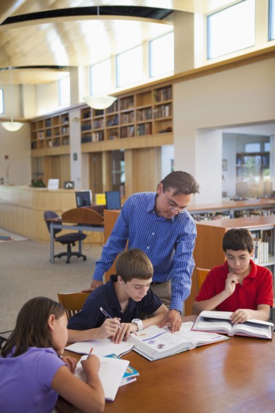 Teacher talking to students in library