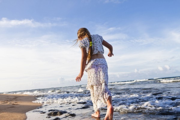Caucasian girl walking on beach