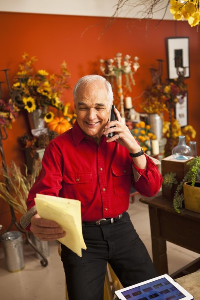 Caucasian florist talking on phone in shop