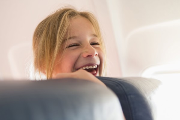 Caucasian girl laughing on airplane
