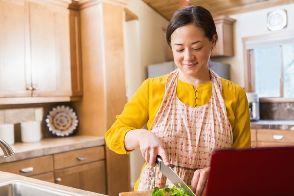 Mixed race woman cooking in kitchen