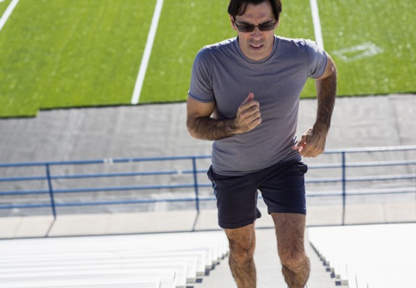 Hispanic athlete running on bleacher steps