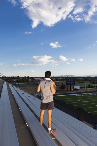 Hispanic athlete standing on bleachers