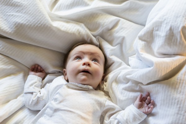 Caucasian baby boy laying in bed