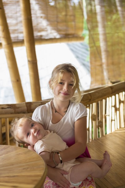 Caucasian girl holding baby sibling
