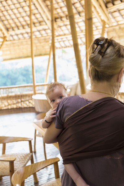 Caucasian mother carrying baby boy on patio