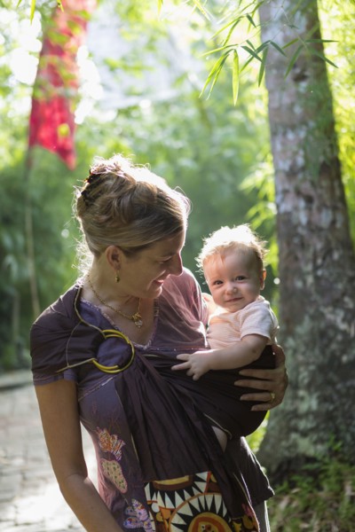 Caucasian mother carrying baby in rainforest