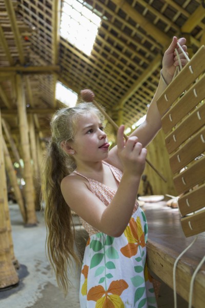 Caucasian girl playing with xylophone in workshop