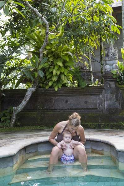 Caucasian mother and baby relaxing in swimming pool
