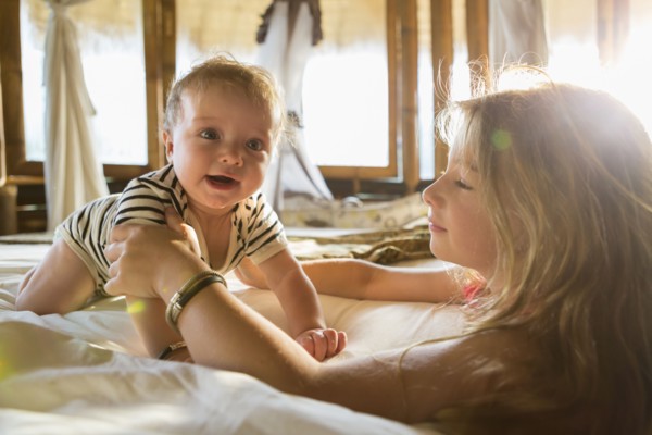 Caucasian children playing on bed