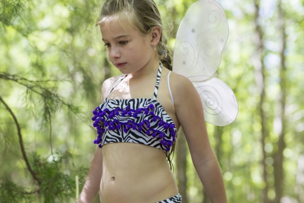 Caucasian girl playing dress up in forest