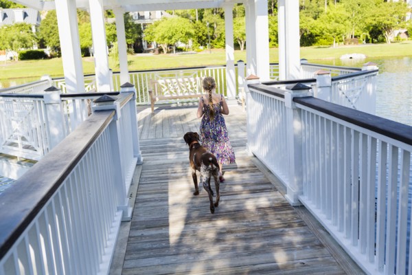 Caucasian girl walking with dog in gazebo