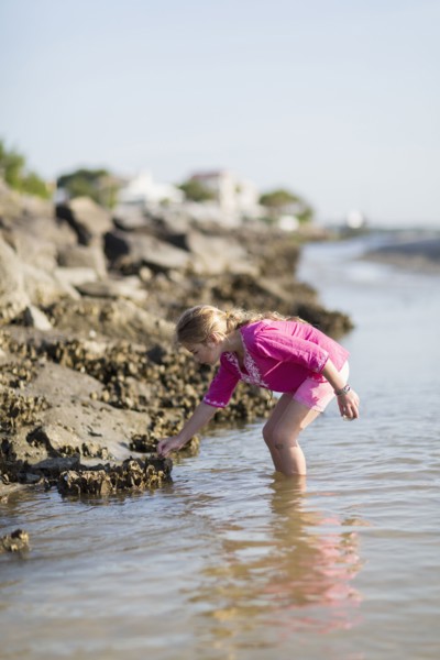 Caucasian girl exploring on rocky beach
