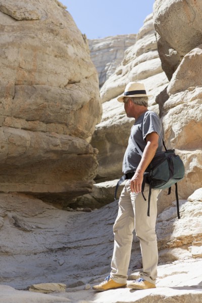 Older Caucasian man exploring rock formations