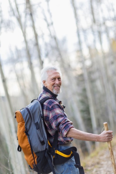 Caucasian hiker walking on dirt path in forest