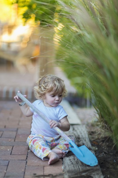Caucasian boy playing with spade in garden