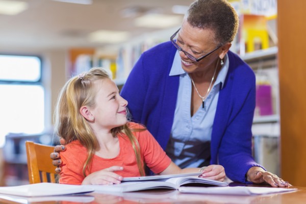 Teacher helping student in library