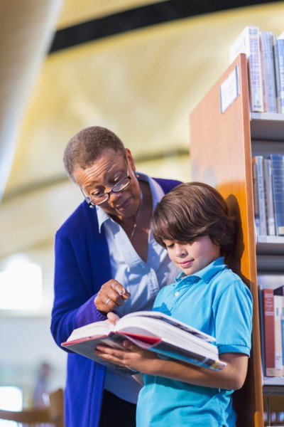 Teacher helping student in library