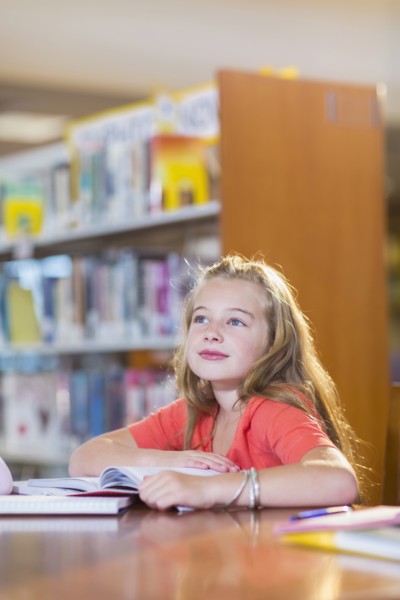 Caucasian student sitting at desk in library