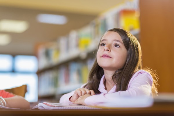 Mixed race student sitting at desk in library