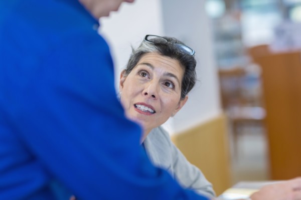 Hispanic teacher helping adult student in library