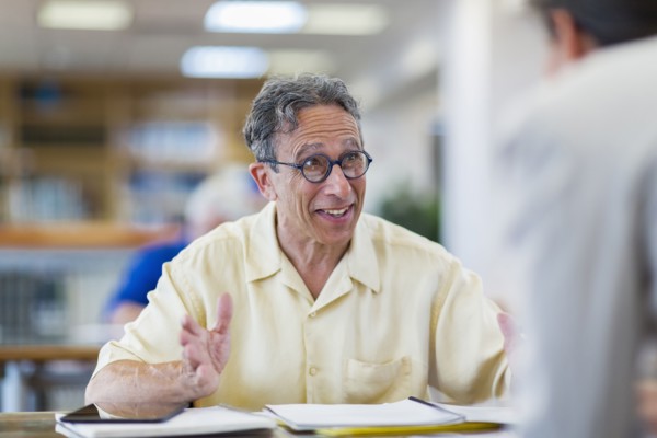 Teacher helping adult student in library