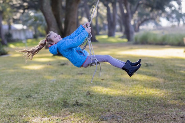 Caucasian girl playing on swing