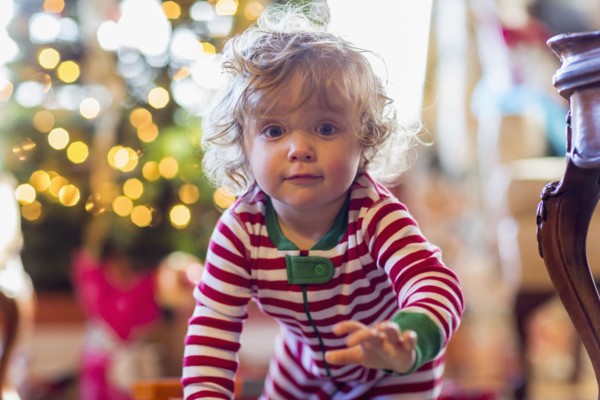 Caucasian baby boy crawling near Christmas tree