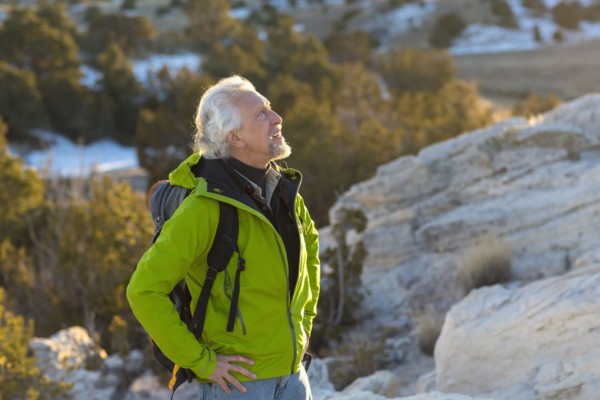 Older man standing on remote rock formations