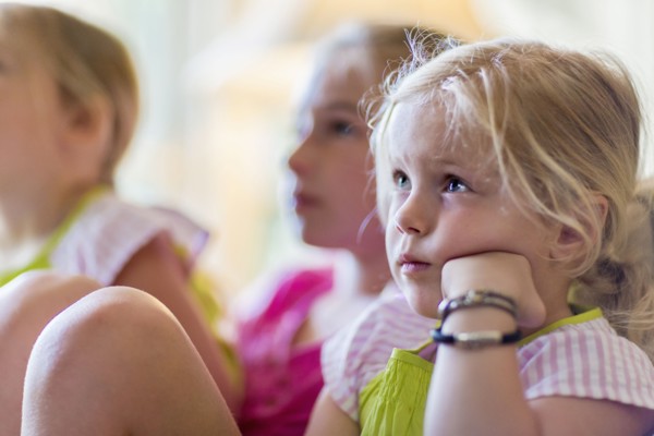 Caucasian girls watching television in armchair