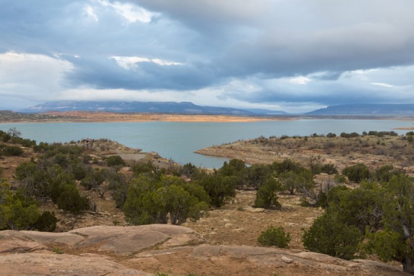 Desert landscape and river under cloudy sky