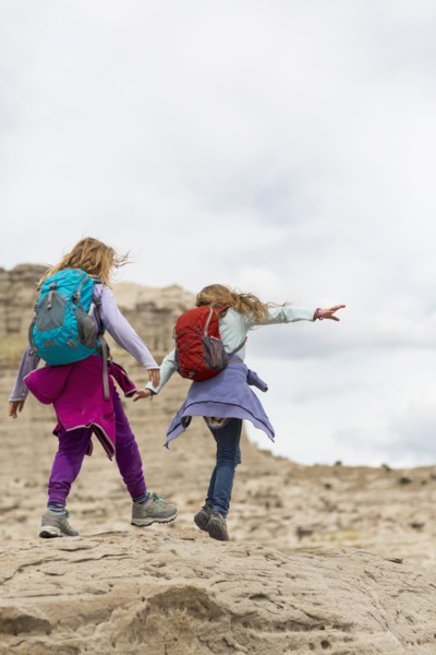 Caucasian girls exploring desert rock formations