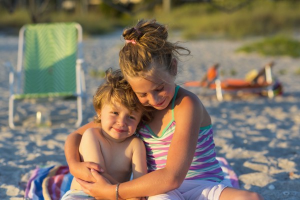 Caucasian children hugging on beach