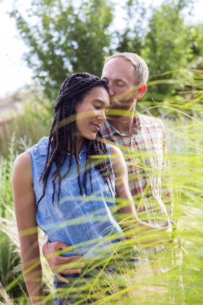 Couple kissing in tall grass in garden