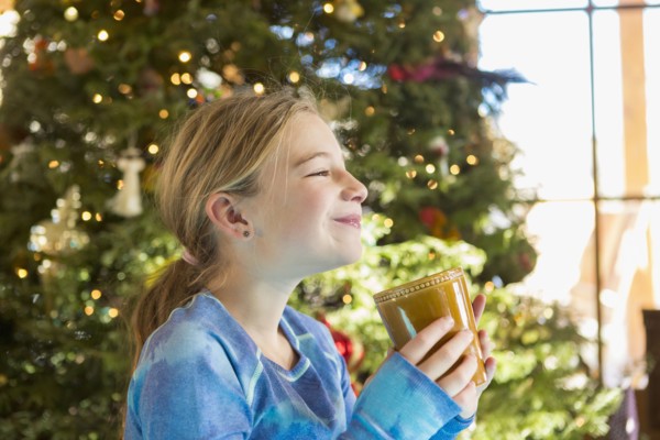 Caucasian girl drinking hot cocoa at Christmas
