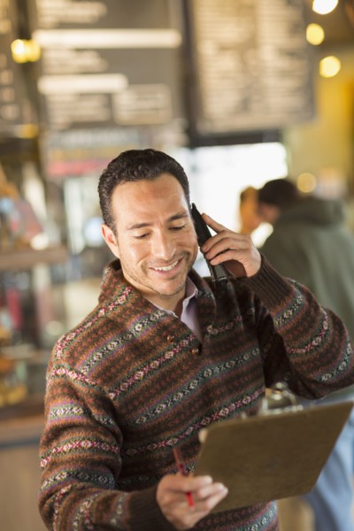 Hispanic businessman talking on telephone in coffee shop