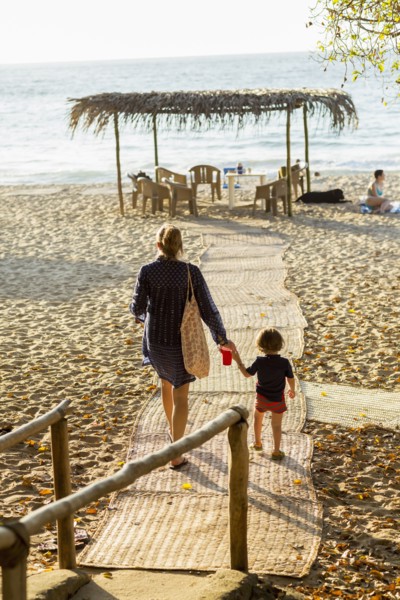 Caucasian mother and son walking on path to beach