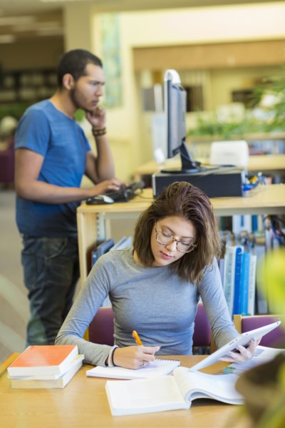 Mixed Race boy and girl studying in library