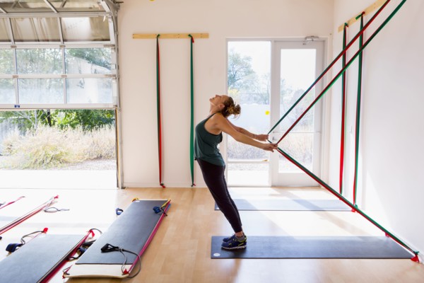 Caucasian woman using resistance bands in gymnasium