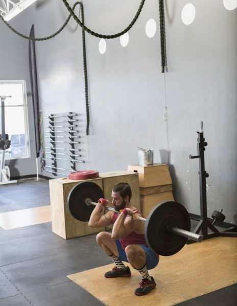 Mixed Race man lifting barbell in gymnasium