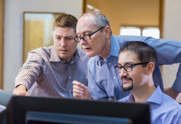 Businessmen talking in office near computer